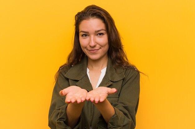 Photo young european woman holding something with palms