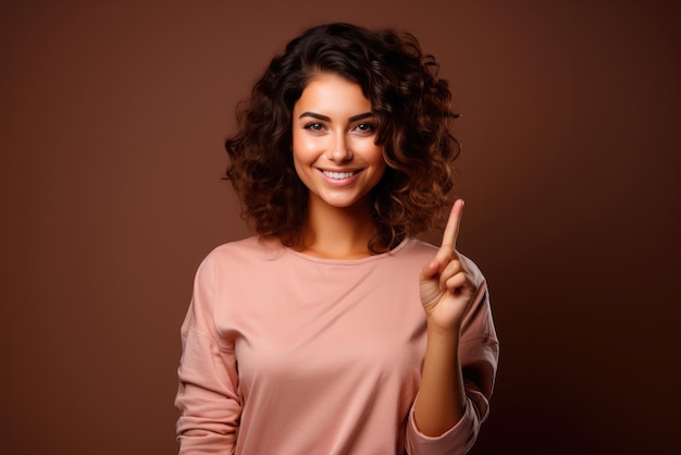 Young european woman in pink clothes on a brown background pointing her finger up with a successful idea