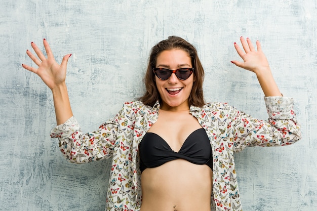 Young european woman wearing bikini being shocked due to an imminent danger