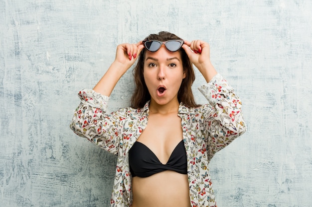 Young european woman wearing bikini keeping eyes opened to find a success opportunity.