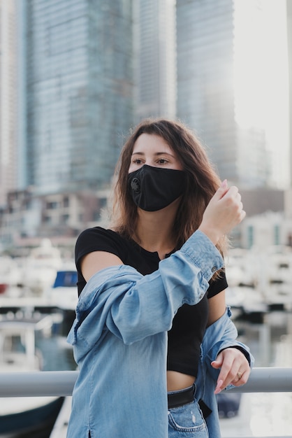 Young european woman with brown hair wearing denim shirt and protective face mask