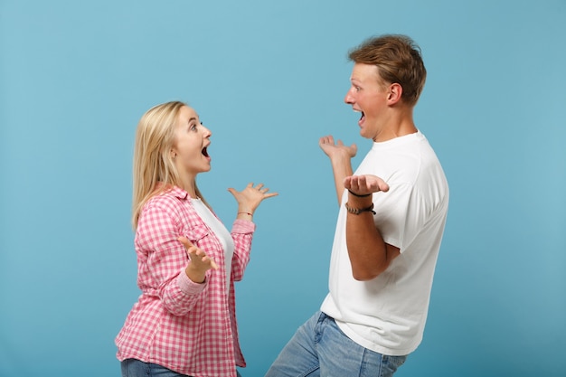 Young excited couple two friend guy girl in white pink blank design t-shirt posing 