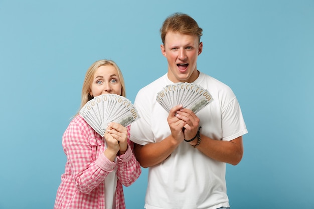 Young excited couple two friends guy and woman in white pink t-shirts posing 