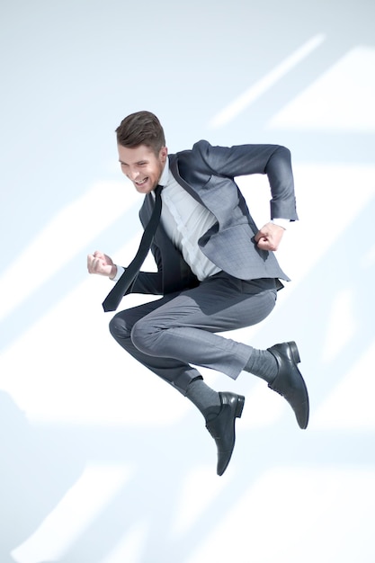 Young excited man jumping up in a jump isolated on a white background