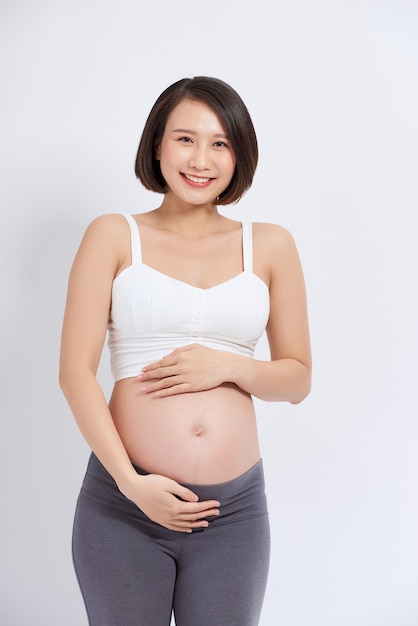 La giovane madre in attesa tenendo il bambino nella pancia incinta.