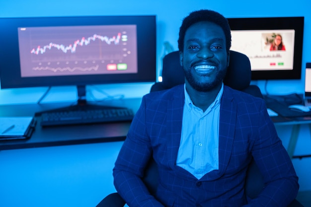 Young expert investor smiling after doing his finances online and evaluating the graphs Concept Entrepreneurship investor business