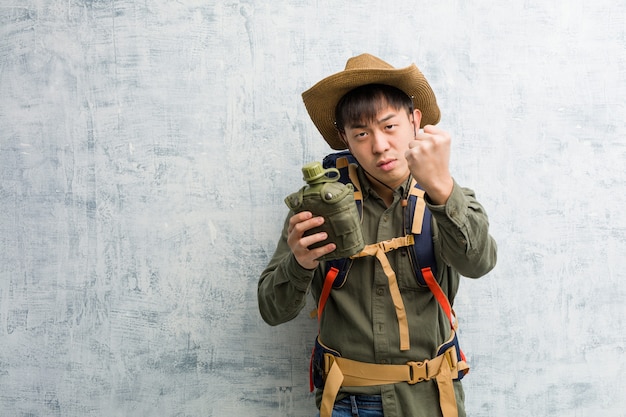 Young explorer chinese man showing fist to front