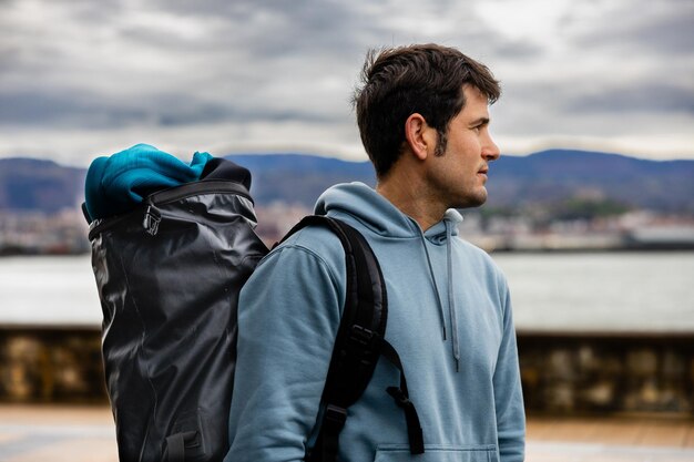 Photo young explorer with backpack at seaside promenade copy space