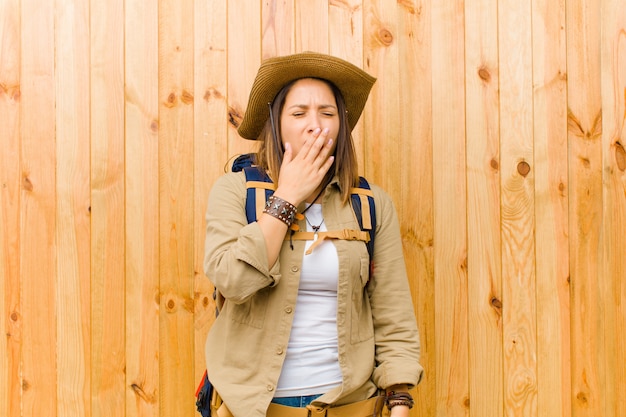 Young  explorer woman against wooden wall