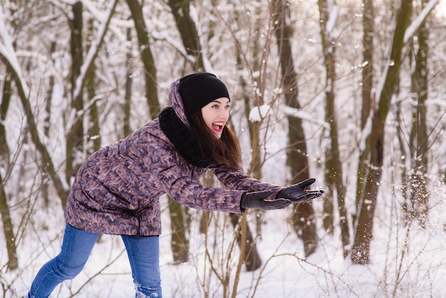 Young expressive woman throw the snow outdoors