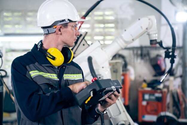 Young factory worker working with adept robotic arm