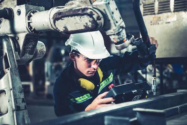 Young factory worker working with adept robotic arm