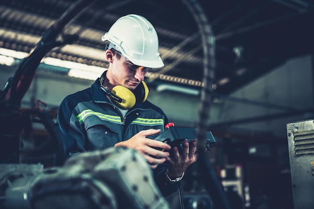 Young factory worker working with adept robotic arm