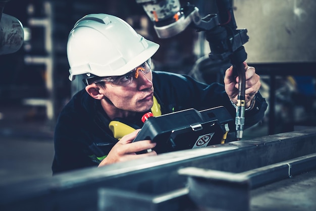 Young factory worker working with adept robotic arm