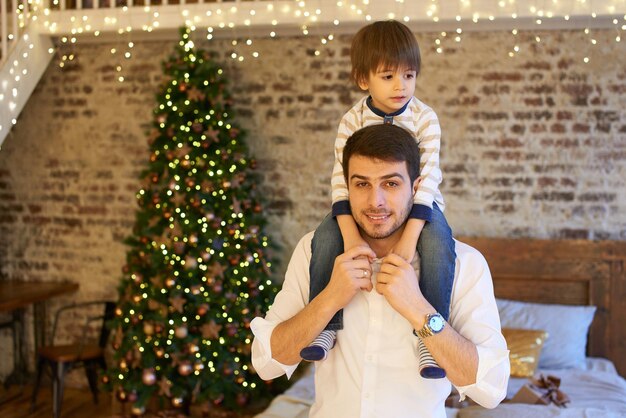 A young family in the apartment decorated for Christmas