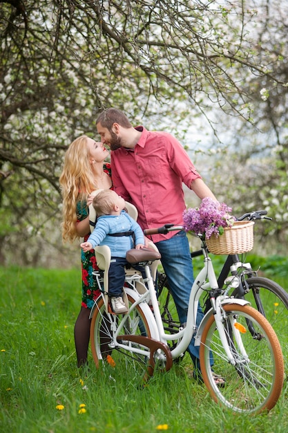 Young family on a bicycles in the spring garden