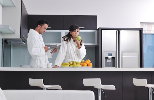 Photo young family couple read newspaper at kitchen in morning with  fresh breakfast  fruits food and coffee drink on table