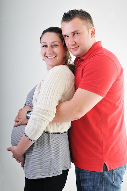 young family couple together in studio isolated on white. happy and waiting for baby