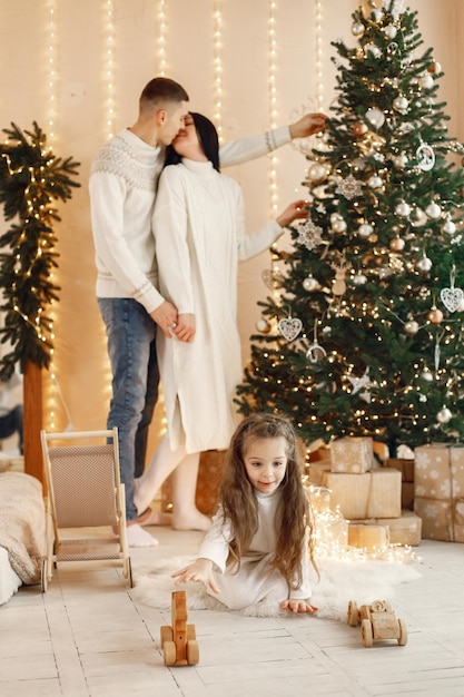 Young family decorating christmas tree and celebrating\
together