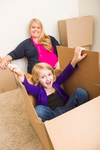 Young Family In Empty Room Playing With Moving Boxes