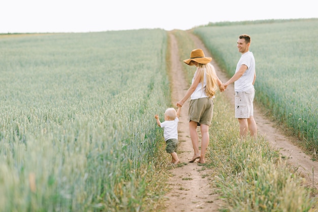 A young family have a fun with their little baby in the field