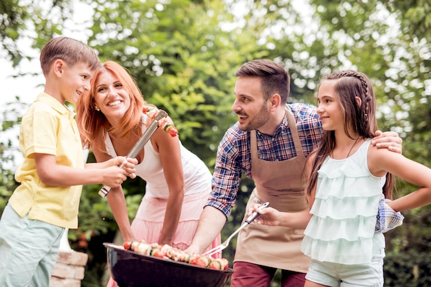 Young family having barbecue party in their garden