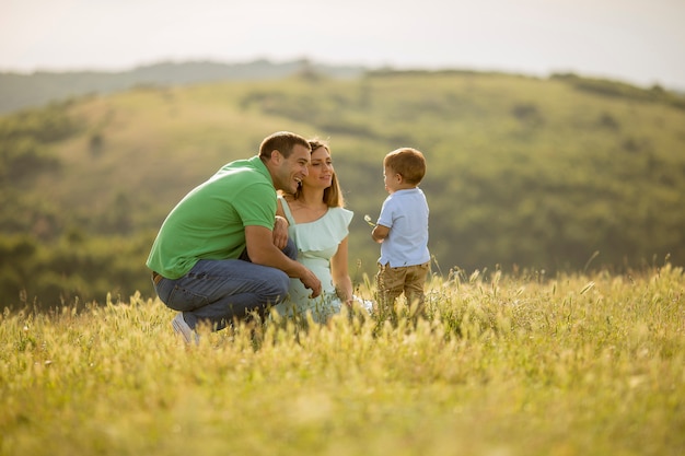 Giovane famiglia divertendosi all'aperto nel campo