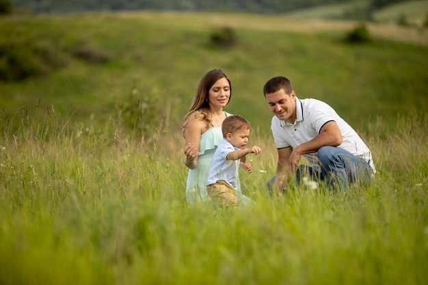 Young family having fun outdoors in the summer field