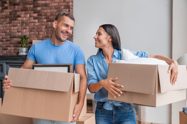 Young family holding cartoon boxes while moving to new home
