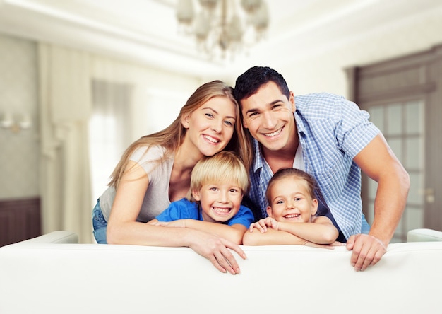 Young  family at home smiling at camera