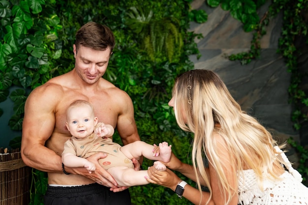 Young family is having fun with their baby in the garden