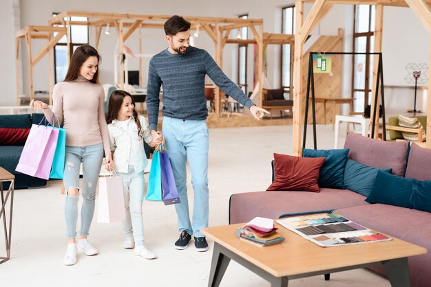 A young family is walking around the furniture store.