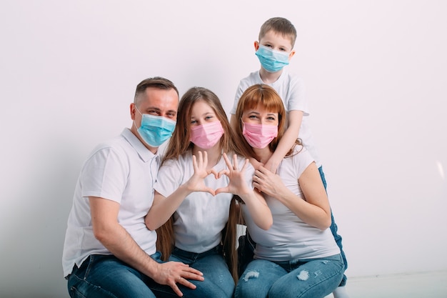 Giovane famiglia in maschere mediche durante la quarantena domestica.