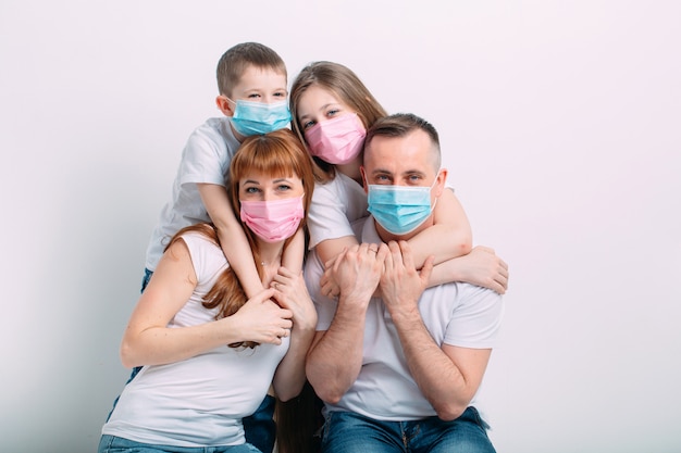 Young family in medical masks during home quarantine.