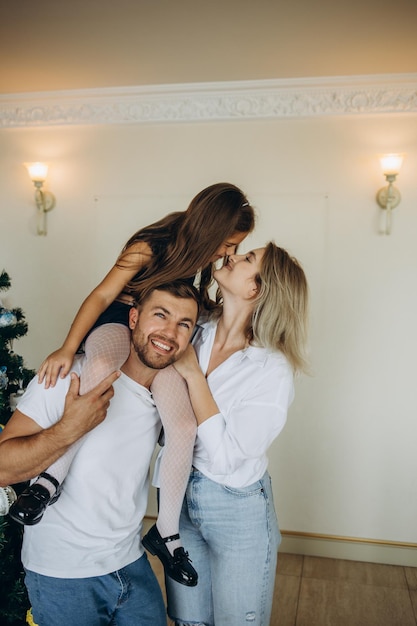 Young family near the Christmas tree on the eve of New Year's holidays