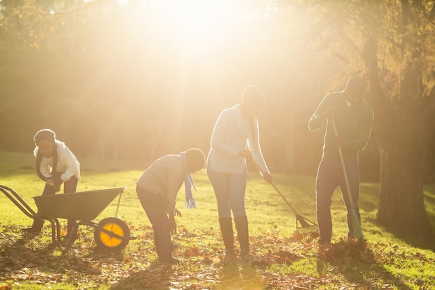 Young family picking up leaves