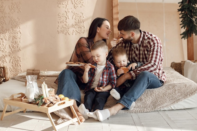 Young family in plaid shirts eating a cookies and hugging