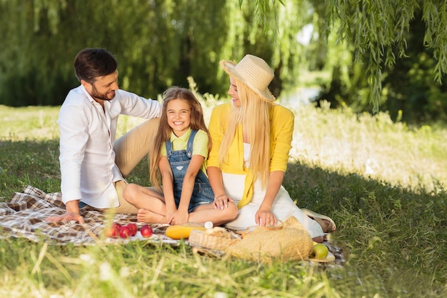 Foto giovane famiglia che si rilassa nel parco sull'erba