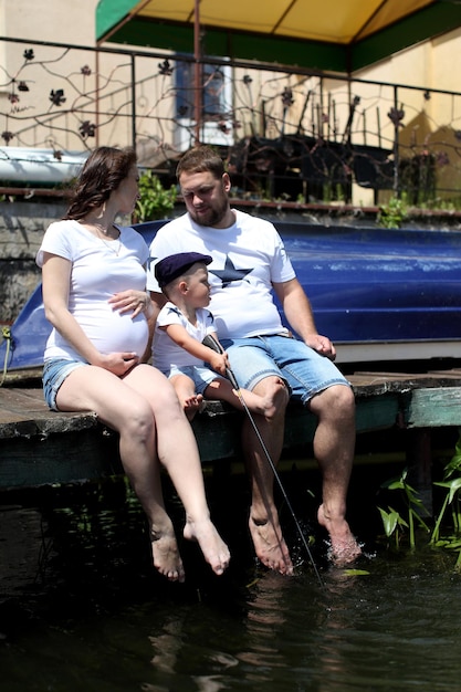 Молодая семья сидит у озера