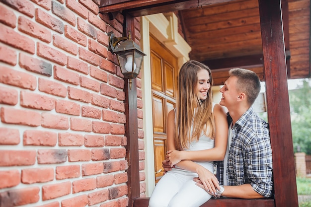 Young family standing at the porch of the house