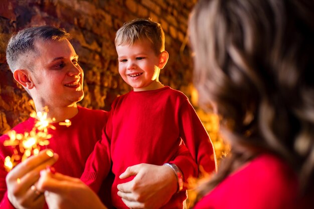 Young family staying at home on Christmas holidays and having quarantine party in living room