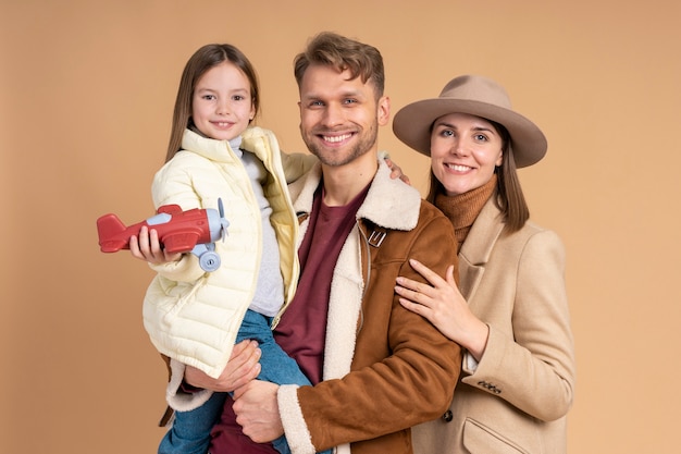 Giovane famiglia di tre persone che posano insieme prima delle vacanze di viaggio