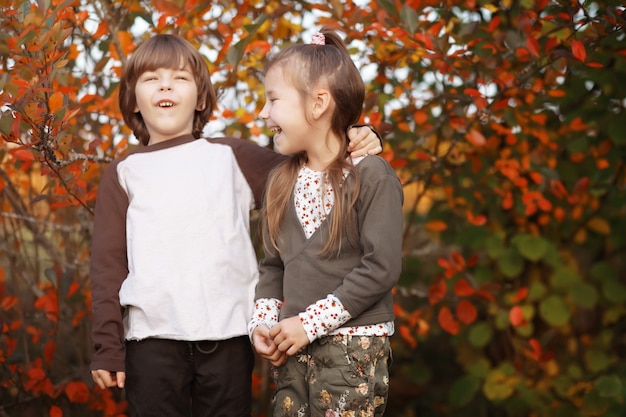 Young family on a walk in the autumn park on a sunny day. Happiness to be together.