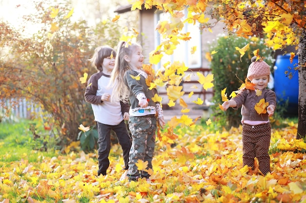 Young family on a walk in the autumn park on a sunny day. Happiness to be together.