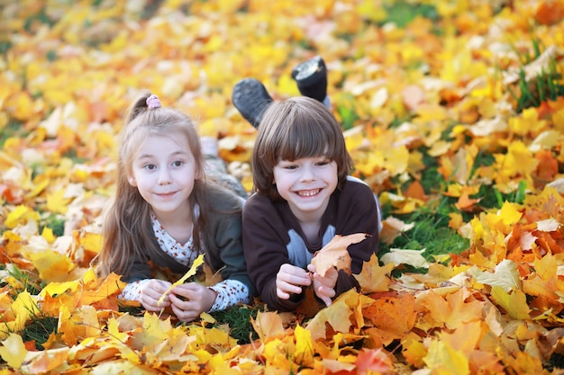 Young family on a walk in the autumn park on a sunny day. Happiness to be together.