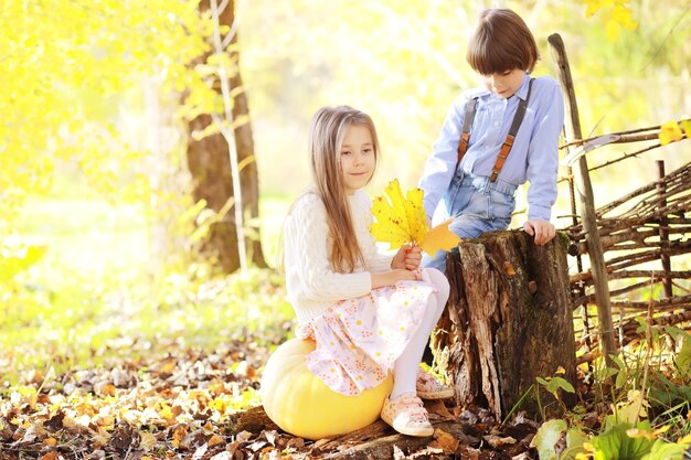 Young family on a walk in the autumn park on a sunny day. Happiness to be together.