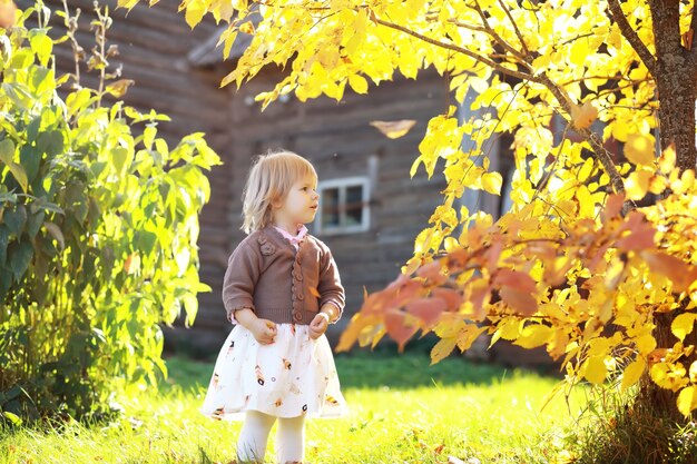 Young family on a walk in the autumn park on a sunny day. Happiness to be together.