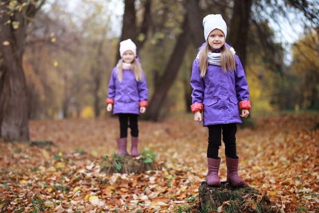 Young family on a walk in the autumn park on a sunny day. Happiness to be together.