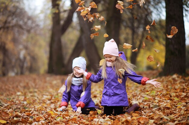 Young family on a walk in the autumn park on a sunny day. Happiness to be together.