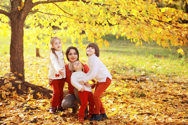 Young family on a walk in the autumn park on a sunny day. Happiness to be together.